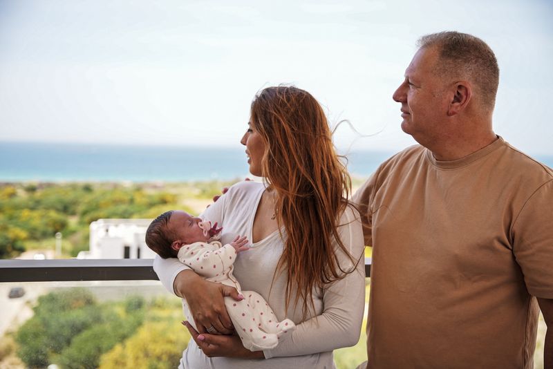 &copy; Reuters. شاي وريعوت هانجبي يلتقطان صورة مع طفلتهما أليكس خلال مقابلة مع رويترز في مسكنهما المؤقت على شاطئ البحر في نهاريا بشمال إسرائيل يوم الأول من 