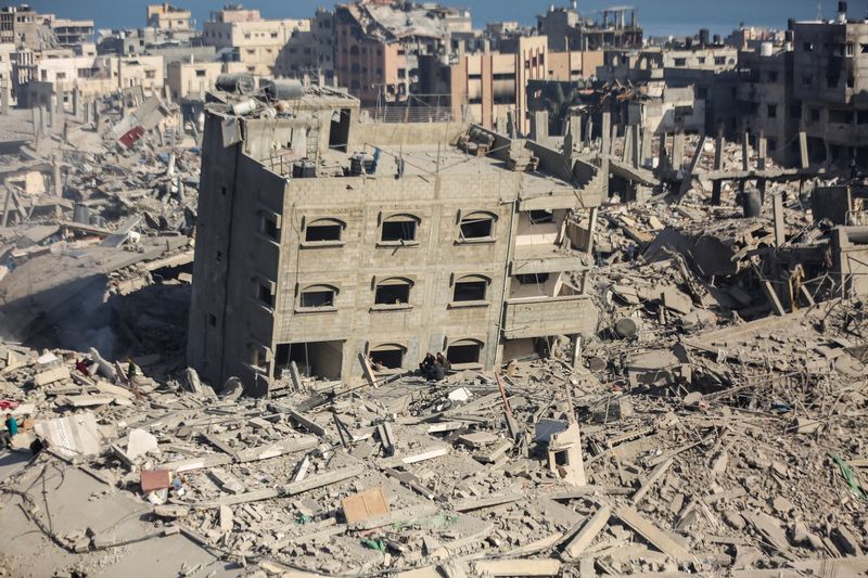 &copy; Reuters. فلسطينيون يتفقدون المنازل والمباني المدمرة في المنطقة المحيطة بمستشفى الشفاء في أعقاب عملية إسرائيلية بمدينة غزة في الأول من أبريل نيسان 20