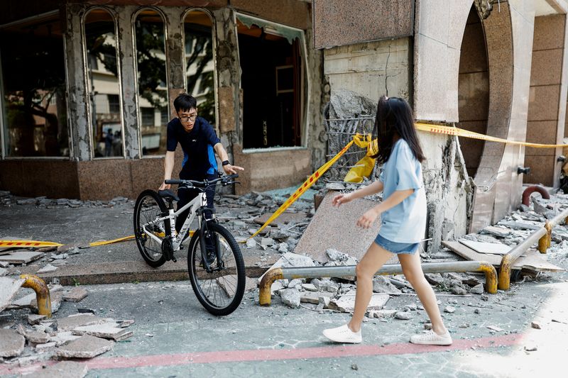 &copy; Reuters. Varias personas trasladan una bicicleta de una tienda de bicicletas en un edificio dañado y la colocan fuera del edificio, tras el terremoto, en Hualien, Taiwán. 4 de abril de 2024. REUTERS/Carlos Garcia Rawlins