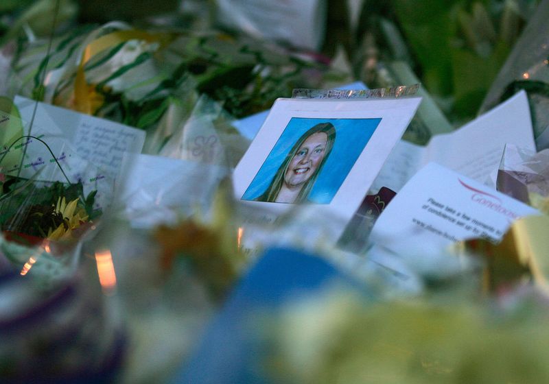 © Reuters. FILE PHOTO: A photograph of murdered Sharon Beshenivsky is seen among the floral tributes left by well-wishers in Bradford November 20, 2005.  REUTERS/Russell Boyce/ File photo