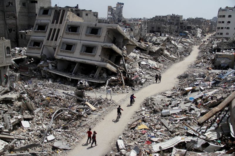 &copy; Reuters. Palestinians ride bicycles past the ruins of houses and buildings destroyed during Israel’ military offensive, amid the ongoing conflict between Israel and the Palestinian Islamist group Hamas, in the northern Gaza Strip March 31, 2024. REUTERS/Mahmoud 