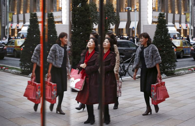 &copy; Reuters. FILE PHOTO: Women are reflected in a window as they pass a boutique in a shopping district in Tokyo, November 26, 2015. REUTERS/Thomas Peter/File photo