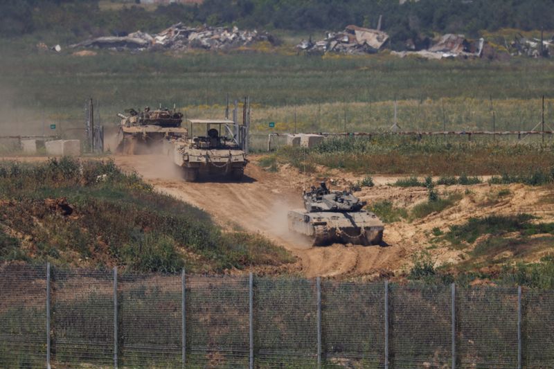 &copy; Reuters. Israeli military vehicles manoeuvre, amid the ongoing conflict between Israel and the Palestinian Islamist group Hamas, by the Israel-Gaza border, as seen from Israel, April 4, 2024. REUTERS/Hannah McKay/File Photo
