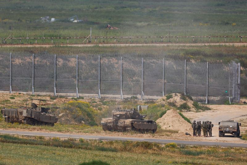 &copy; Reuters. Israeli soldiers stand near military vehicles, amid the ongoing conflict between Israel and the Palestinian Islamist group Hamas, near the Israel-Gaza border, as seen from Israel, April 4, 2024. REUTERS/Hannah McKay