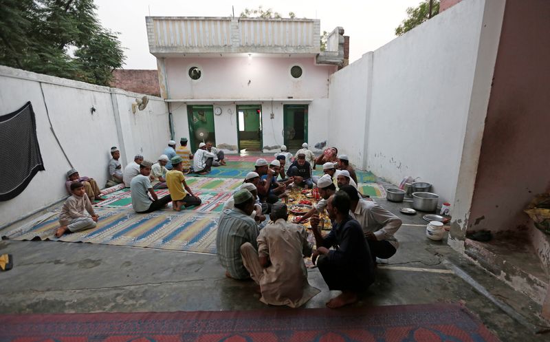 &copy; Reuters. FILE PHOTO: Muslims eat their Iftar (breaking of fast) meal during the holy month of Ramadan inside a madrasa that also acts as a mosque in village Nayabans in the northern state of Uttar Pradesh, India May 9, 2019. REUTERS/Adnan Abidi/File Photo