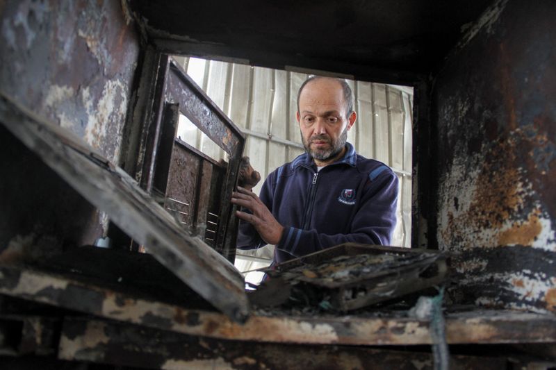 © Reuters. FILE PHOTO: Palestinian owner of furnishing business Mohammed AL Safi inspects damaged equipment inside his workshop which was hit in an Israeli strike, in Jabalia in the northern Gaza Strip March 30, 2024. REUTERS/Mahmoud Issa/File Photo