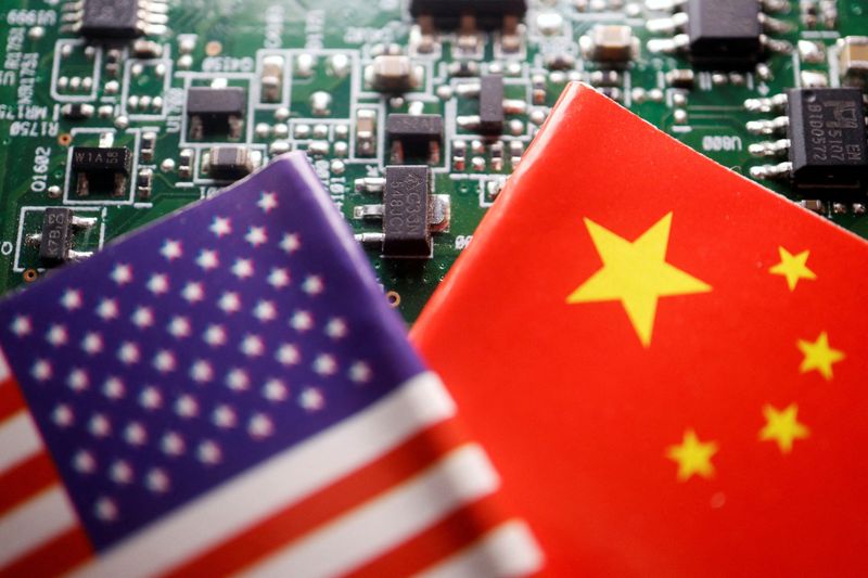 &copy; Reuters. Illustration d'archives des drapeaux de la Chine et des États-Unis visibles sur une carte de circuit imprimé avec des semi-conducteurs. /Photo prise le 17 février 2023/REUTERS/Florence Lo