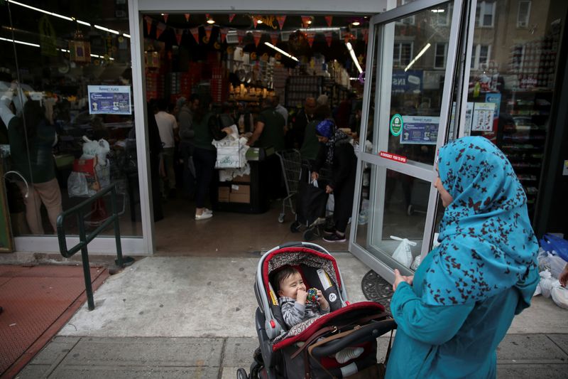 &copy; Reuters. FILE PHOTO: A Muslim American woman wearing hijab awaits outside the Balady halal supermarket with a child ahead of the first day of Ramadan in Brooklyn, New York, U.S. on May 26, 2017. REUTERS/Amr Alfiky/File Photo