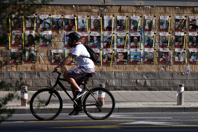 © Reuters. A man cycles past posters with pictures of hostages kidnapped in the deadly October 7 attack on Israel by the Palestinian Islamist group Hamas from Gaza, as the conflict between Israel and Hamas continues, in Tel Aviv, Israel, April 6, 2024. REUTERS/Hannah McKay