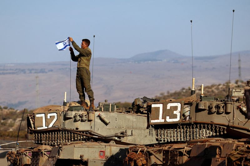 © Reuters. FILE PHOTO: A soldier installs an Israeli flag on a tank during a military drill near Israel's border with Lebanon in northern Israel, October 26, 2023. REUTERS/Lisi Niesner/File Photo
