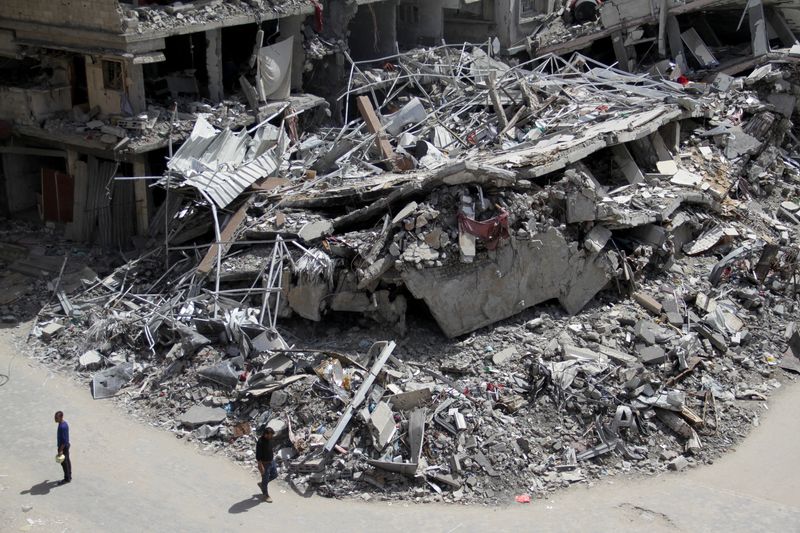 &copy; Reuters. فلسطينيون يمرون بأنقاض منازل تدمرت جراء القصف الإسرائيلي في شمال قطاع غزة يوم 31 مارس آذار 2024. تصوير: محمود عيسى - رويترز