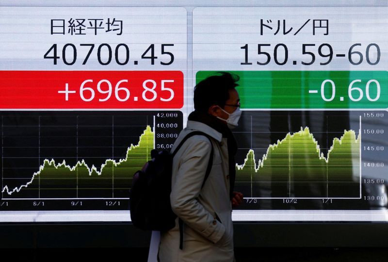 &copy; Reuters. FILE PHOTO: A man walks past an electric screen displaying Japan's Nikkei share average and the current Japanese Yen exchange rate against the U.S. dollar outside a brokerage in Tokyo, Japan March 21, 2024.  REUTERS/Issei Kato/File Photo