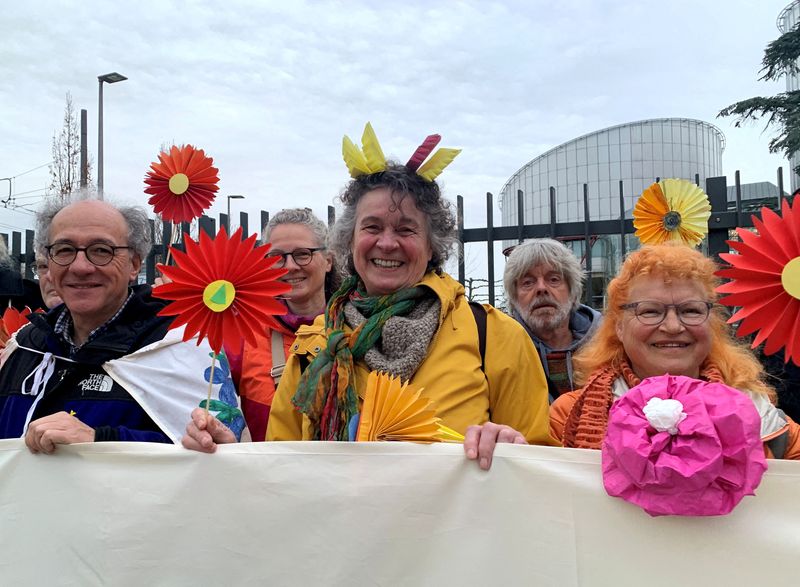 &copy; Reuters. FILE PHOTO: Supporters of the Senior Women for Climate Protection association hold paper flowers and a banner outside the European Court of Human Rights in Strasbourg, France March 29, 2023. REUTERS/Emma Farge/File Photo