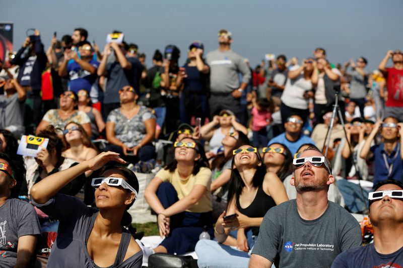 &copy; Reuters. أشخاص يشاهدون كسوف الشمس في مدينة لوس انجليس بولاية كاليفورنيا الأمريكية بصورة من أرشيف رويترز.