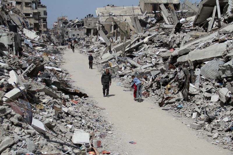 &copy; Reuters. FOTO DE ARCHIVO. Palestinos pasan junto a las ruinas de casas y edificios destruidos durante la ofensiva militar de Israel, en medio del conflicto en curso entre Israel y el grupo islamista palestino Hamás, en el norte de la Franja de Gaza, el 31 de marz