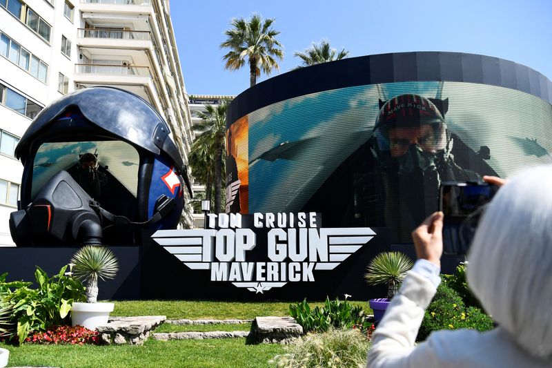 &copy; Reuters. FILE PHOTO: The 75th Cannes Film Festival - The Croisette - Cannes, France, May 18, 2022. A woman takes a photo of a giant advertising pilot helmet broadcasting a movie trailer for the film "Top Gun: Maverick" with cast member Tom Cruise. REUTERS/Piroschk