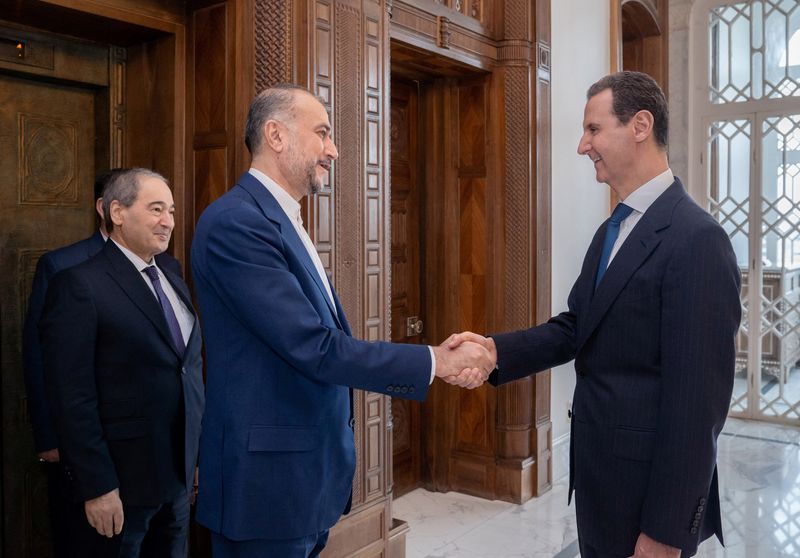 &copy; Reuters. イランのアブドラヒアン外相は８日、シリアの首都ダマスカスにあるイラン大使館で新たな領事部の建物を開設した。写真はシリアのアサド大統領と握手するアブドラヒアン外相。４月８日