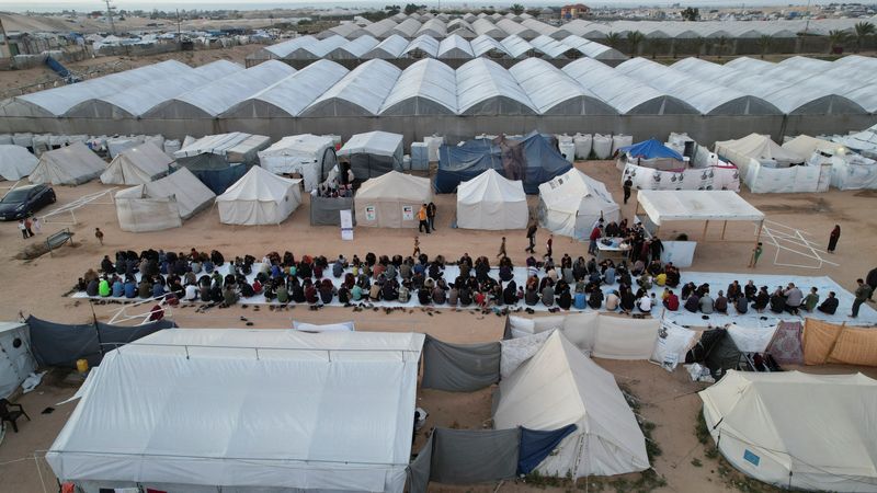 &copy; Reuters. Une vue de drone montre des Palestiniens, qui ont été déplacés par l'offensive militaire israélienne, se rassemblant pour l'Iftar (rupture du jeûne) pendant le mois sacré du Ramadan, à Rafah dans le sud de la bande de Gaza. /Photo prise le 6 avril