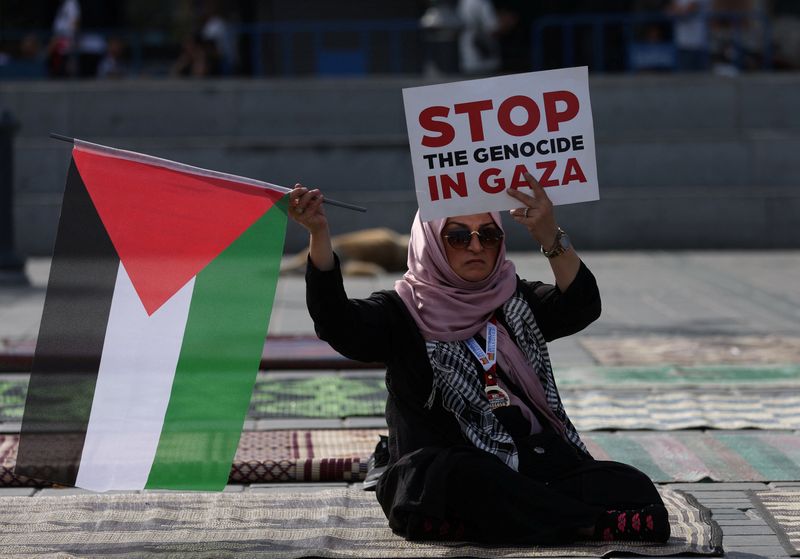 &copy; Reuters. امرأة تحمل علما فلسطينا ولافتة تنص "أوقفوا الإبادة في غزة" خلال مظاهرة لدعم الفلسطينين في غزة في إسطنبول بتركيا يوم 22 أكتوبر تشرين الأول 2023. 