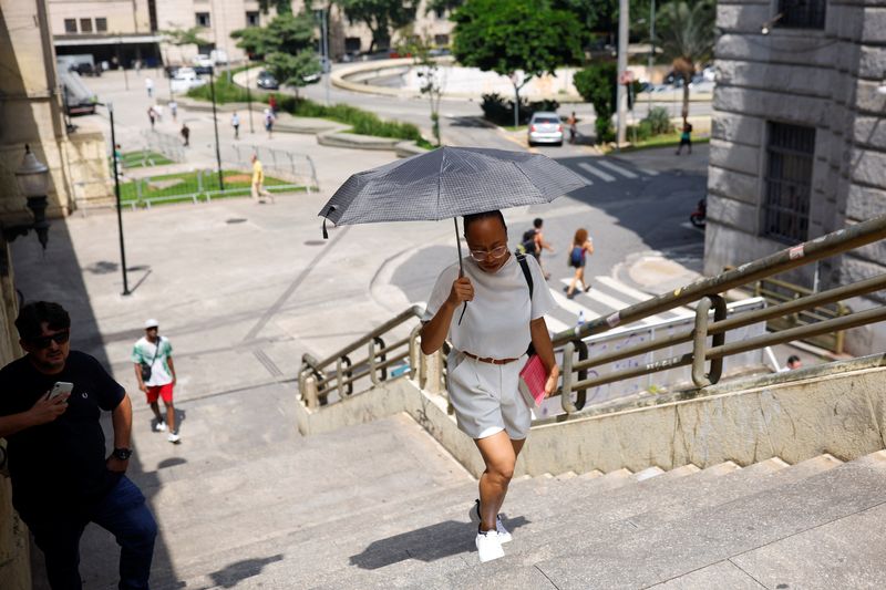 &copy; Reuters. امرأة تحمل مظلة لتحمى لنفسها من أشعة الشعة وسط موجة حرارة في ساو باولو بالبرازيل يوم 15 مارس آذار 2024. تصوير: أماندا بيروبيلي - رويترز.
