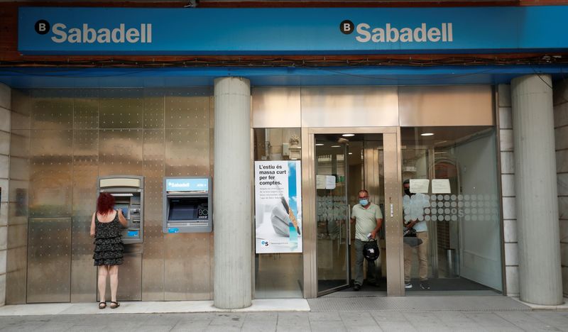 &copy; Reuters. A woman uses an ATM machine as people leave a Sabadell bank office in Barcelona, Spain, September 7, 2021. REUTERS/ Albert Gea/File Photo