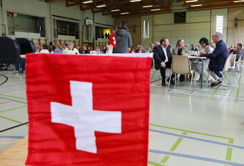 &copy; Reuters. A Swiss flag is pictured in front of President Guy Parmelin at a meeting with locals during the annual field trip of the Swiss Federal Council in Le Sentier, Switzerland, July 1, 2021.   REUTERS/Denis Balibouse/File Photo