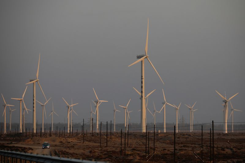 &copy; Reuters. Un'auto guida vicino alle turbine eoliche di una centrale elettrica vicino a Yumen, nella provincia di Gansu, in Cina, 29 settembre 2020. REUTERS/Carlos Garcia Rawlins