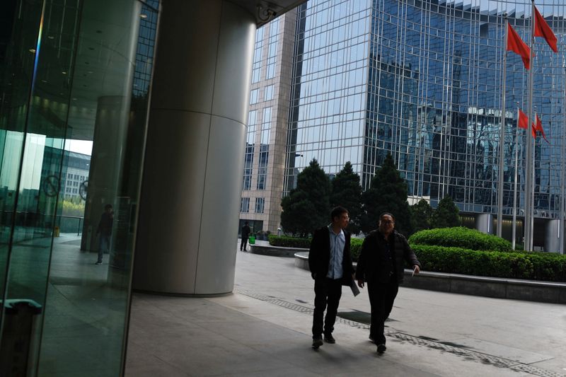 © Reuters. People walk past an office and shopping complex in Beijing, China April 10, 2024. REUTERS/Tingshu Wang