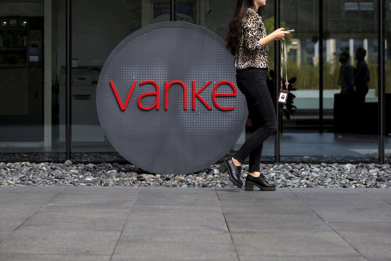 &copy; Reuters. An employee walks past a logo of Vanke at its headquarters in Shenzhen, south China's Guangdong province, November 2, 2015. REUTERS/Tyrone Siu/File Photo