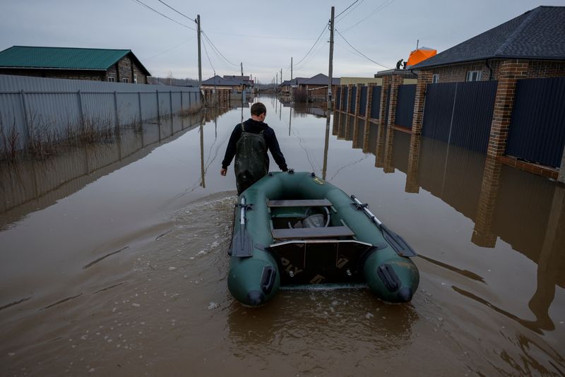 &copy; Reuters. FILE PHOTO: A man tows an inflatable boat along a flooded street in in the settlement of Ivanovskoye, Orenburg region, Russia, April 10, 2024. REUTERS/Maxim Shemetov/File Photo