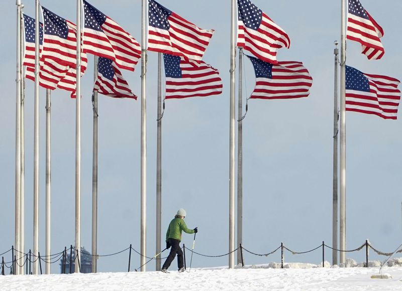 &copy; Reuters. FILE PHOTO: A cross-country skier passes beneath flags at the Washington Monument after a snowfall in Washington, U.S., January 16, 2024. REUTERS/Kevin Lamarque/File Photo