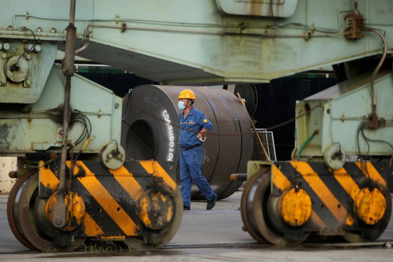 &copy; Reuters. FILE PHOTO: An employee walks past rolled steel at a port during a government-organised media tour to Baoshan Iron & Steel Co., Ltd. (Baosteel), a subsidiary of China Baowu Steel Group, in Shanghai, China September 16, 2022. REUTERS/Aly Song/File photo