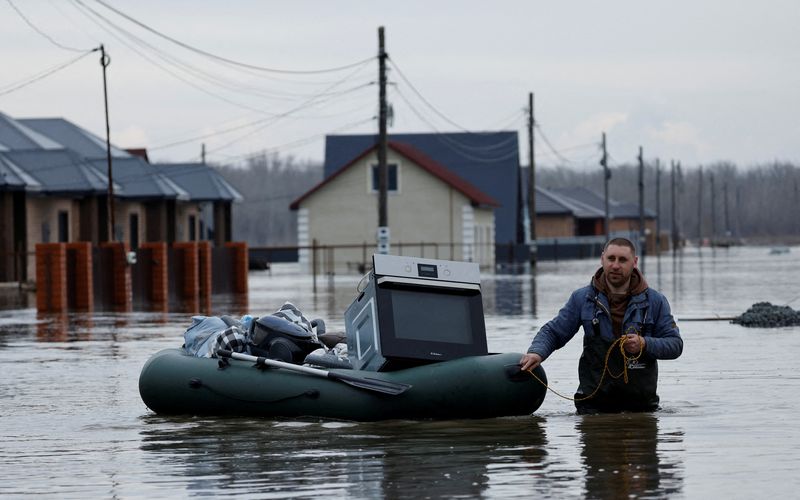 &copy; Reuters. A man tows an inflatable boat with his belongings along a flooded street in the settlement of Ivanovskoye, Orenburg region, Russia, April 10, 2024. REUTERS/Maxim Shemetov     TPX IMAGES OF THE DAY