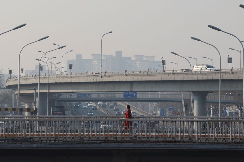 &copy; Reuters. A pedestrian walks on an overpass past car traffic in Beijing, China January 12, 2024. REUTERS/Florence Lo/File Photo