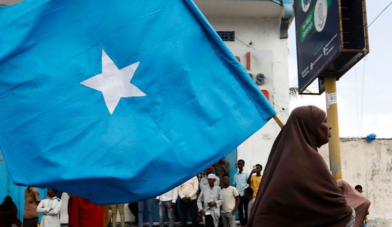 &copy; Reuters. امرأة صومالية تحمل علم بلادها خلال احتجاج على اتفاق إثيوبي مع منطقة أرض الصومال الانفصالية تتيح بموجبه أرض الصومال لإثيوبيا إنشاء قاعدة بح