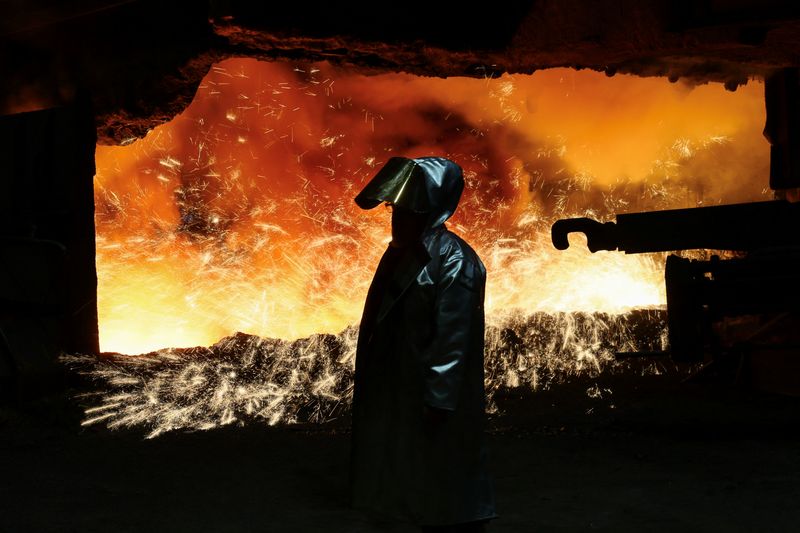 &copy; Reuters. FILE PHOTO: A steel worker in heat protection gear is silhouetted against the sparkling fire of Europe’s largest  furnace with its daily raw iron production of 12,000 tons, at the steel plant of ThyssenKrupp in Duisburg, Germany, November 16, 2023.  REU