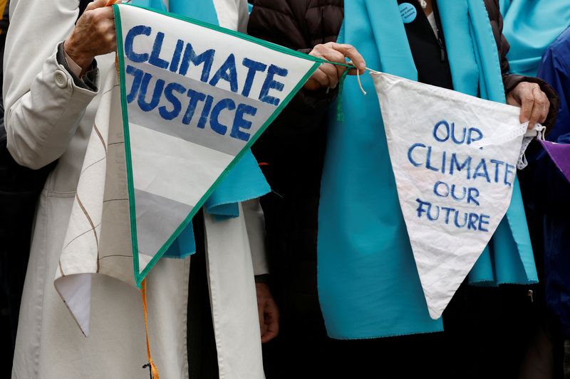 &copy; Reuters. Simpatizantes y miembros de la asociación Mujeres Mayores por la Protección del Clima sostienen pancartas a su llegada a la sentencia del caso climático Verein KlimaSeniorinnen Schweiz y otros contra Suiza, en el Tribunal Europeo de Derechos Humanos (T