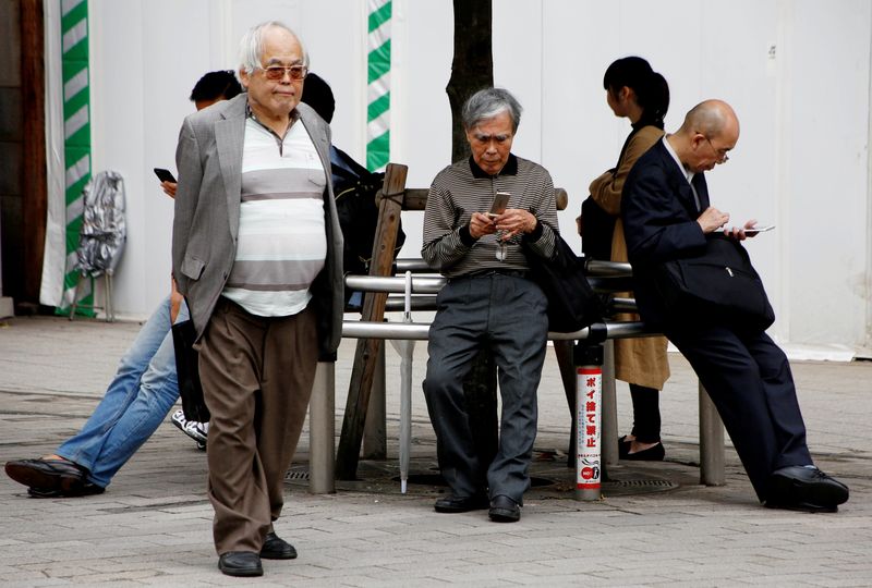 &copy; Reuters. عدد من الرجال كبار السن ينتظرون في محطة للحافلات بطوكيو في صورة من أرشيف رويترز.