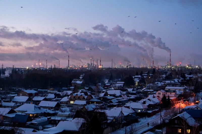 &copy; Reuters. FILE PHOTO: Birds fly above buildings as flue gas and steam rise out of chimneys and smokestacks of an oil refinery during sunset on a frosty day in the Siberian city of Omsk, Russia, February 8, 2023. REUTERS/Alexey Malgavko/File Photo