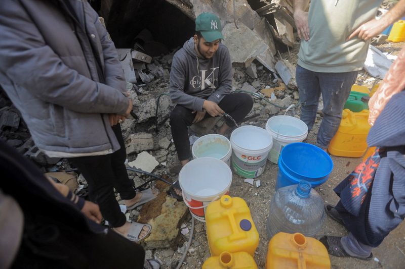 &copy; Reuters. فلسطينيون ينتقلون المياه من منزل دمرته غارة إسرائيلية في مخيم جباليا للاجئين في شمال قطاع غزة في السابع من فبراير شباط 2024. تصوير: محمود عيسى 