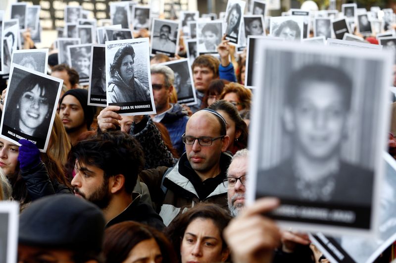&copy; Reuters. أشخاص يحملون صور ضحايا تفجير مقر الرابطة الأرجنتينية اليهودية المشتركة خلال مراسم بمناسبة الذكرى 22 لهجوم عام 1994 والذي أسفر عن مقتل 85 شخصا ف