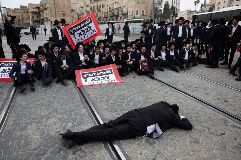 © Reuters. FILE PHOTO: Ultra-Ortodox Jewish men protest against attempts to change government policy that grants ultra-Orthodox Jews exemptions from military conscription in Jerusalem February 26, 2024. REUTERS/Ronen Zvulun/File Photo