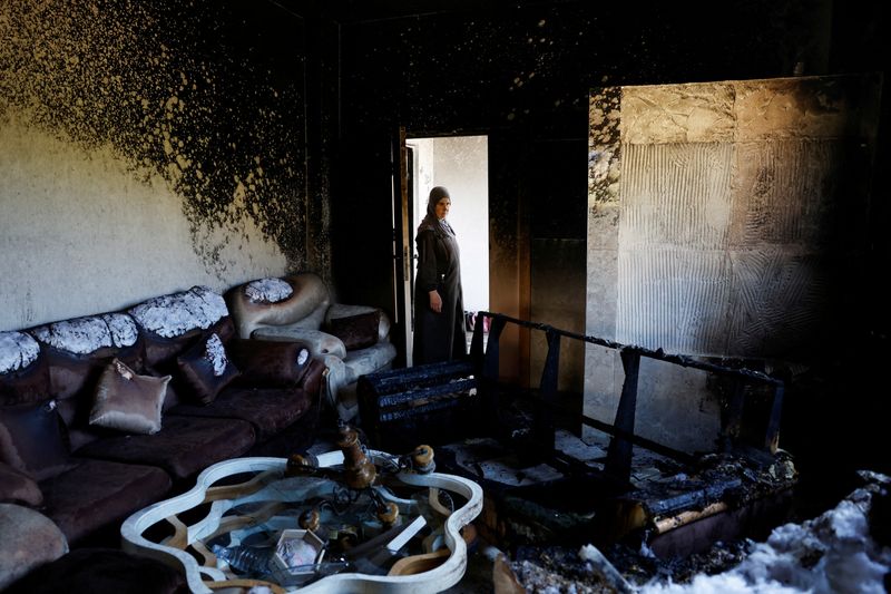© Reuters. Una mujer palestina inspecciona los daños causados en una casa tras el ataque de colonos israelíes a la aldea de al-Mughayyer, en Cisjordania ocupada por Israel. 13 de abril de 2024. REUTERS/Mohammed Torokman