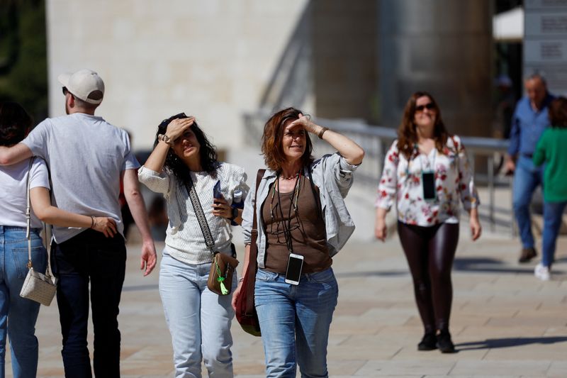 &copy; Reuters. سيدتان تغطيان أعينهما لحمايتها من أشعة الشمس بسبب ارتفاع درجات الحرارة في مدينة بيلباو بشمال غرب إسبانيا في يوم 13 أبريل نيسان 2024 . تصوير: فنس