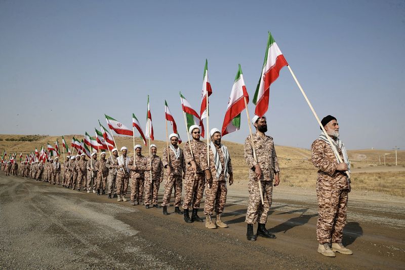 &copy; Reuters. أفراد من قوات الحرس الثوري الإيراني يحملون الأعلام الإيرانية بصورة من أرشيف رويترز.