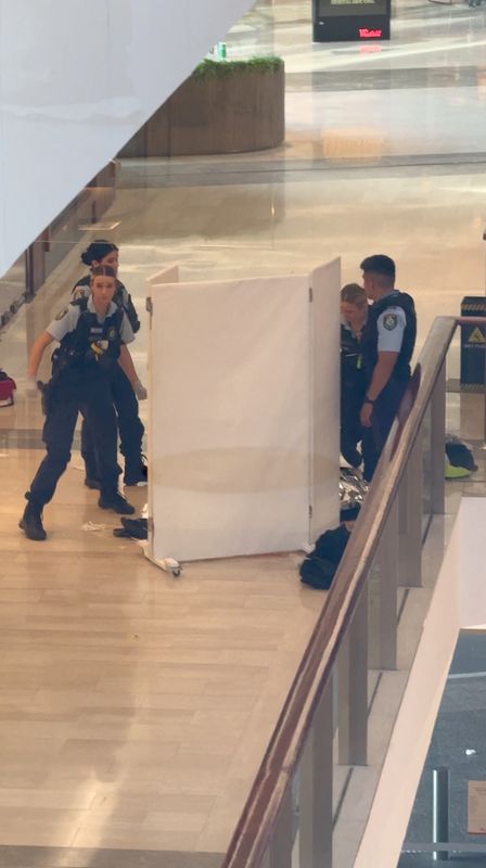 &copy; Reuters. ضباط شرطة يقفون بالقرب من مسرح الجريمة داخل مركز تسوق حيث وقع حادث طعن في سيدني بأستراليا يوم 13 أبريل نيسان 2024 في صورة مأخوذة من مقطع مصور مت