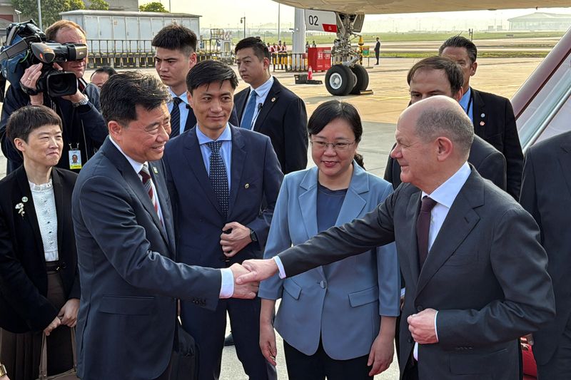 © Reuters. German Chancellor Olaf Scholz shakes hands with Chinese Ambassador to Germany Wu Ken next to Chongqing Vice Mayor Zhang Guozhi, upon arriving at the airport in Chongqing, China April 14, 2024. REUTERS/Andreas Rinke