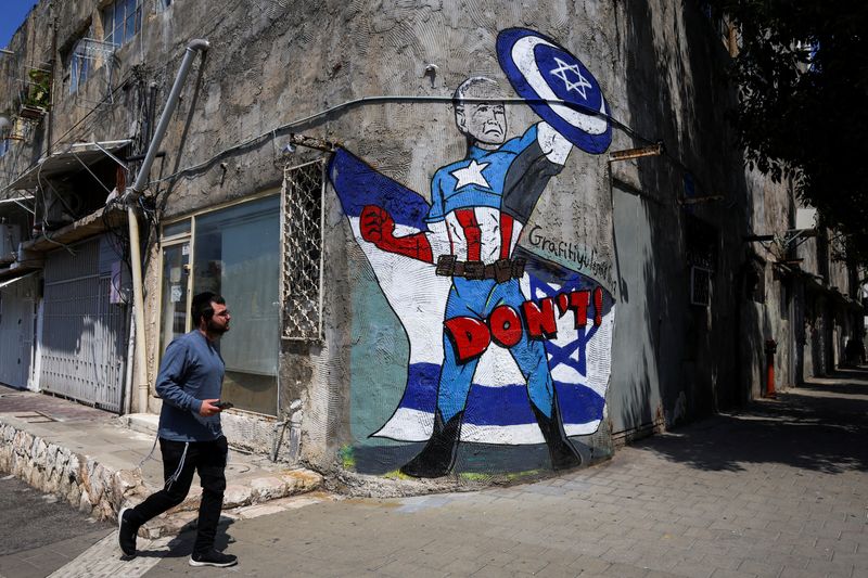 &copy; Reuters. Un hombre pasa junto a una pintada que representa al presidente de Estados Unidos, Joe Biden, como el superhéroe Capitán América en Tel Aviv, Israel. 14 de abril de 2024. REUTERS/Hannah McKay     