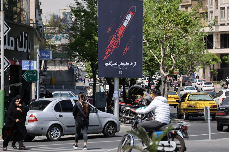 &copy; Reuters. Un grupo de personas pasa junto a un cartel contra Israel en una calle de Teherán, Irán. 14 de abril de 2024. Majid Asgaripour/WANA (Agencia de Noticias de Asia Occidental) vía REUTERS. ATENCIÓN EDITORES - ESTA IMAGEN HA SIDO ENTREGADA POR TERCEROS.