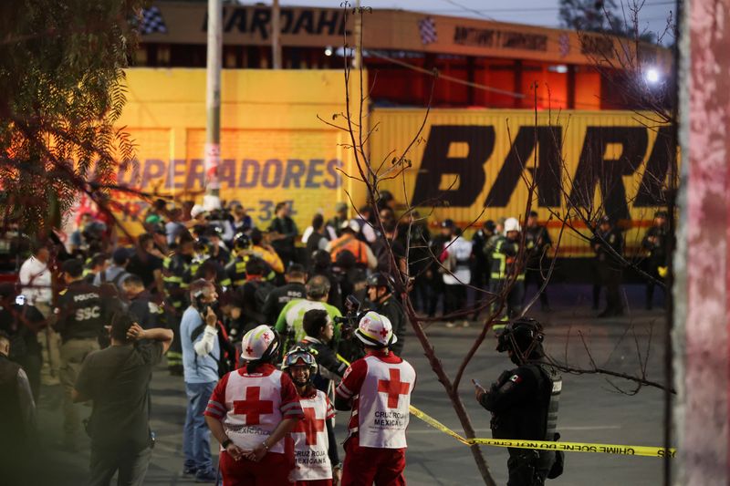 © Reuters. Equipos de emergencia en el lugar donde cayó un helicóptero sobre un taller de reparación de autobuses de transporte en Ciudad de México, México, el 14 de abril, 14, 2024. REUTERS/Luis Cortes